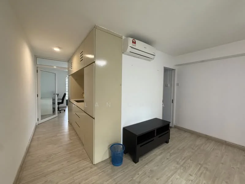 Room features: light wood laminate flooring, white painted walls, built-in cabinetry with cream finish, wall-mounted air conditioning unit, black TV console, glass door leading to another room, recessed ceiling lights, blue waste bin; style: modern.