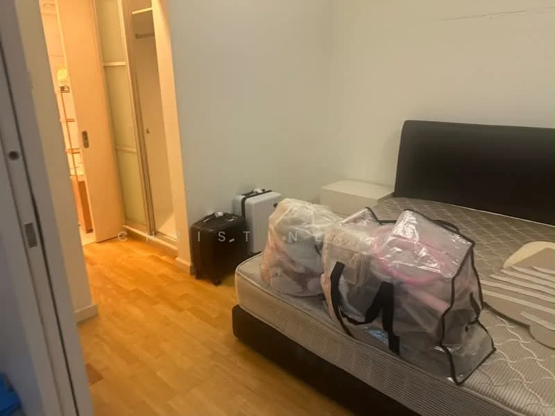 Bedroom features: wooden flooring, queen-size bed, black upholstered headboard, white bedside table, two transparent storage bags, white linens, closet with sliding doors, wall-mounted mirror. Room features: light-colored walls, doorway leading to bathroom, visible luggage.