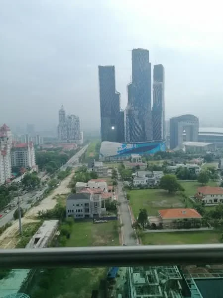 Exterior type: high-rise condominium; features: glass curtain wall, modern architectural design, surrounded by greenery, urban skyline view, adjacent to road, multiple high-rise buildings, open space in foreground, manicured lawns, residential houses in vicinity; style: modern.
