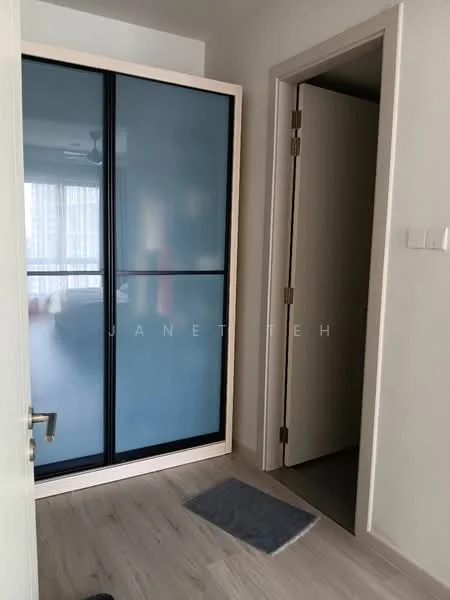 Room features: sliding glass door wardrobe with frosted blue panels, light wood cabinetry, light wood flooring, white walls, doorway leading to another room, door with a simple design, small area rug, natural light from adjacent room; style: modern.