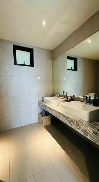 Bathroom features: grey tiled walls, light grey floor tiles, double sink with rectangular basin, marble countertop, large wall-mounted mirror, recessed lighting, small square windows, wooden storage basket; style: modern.