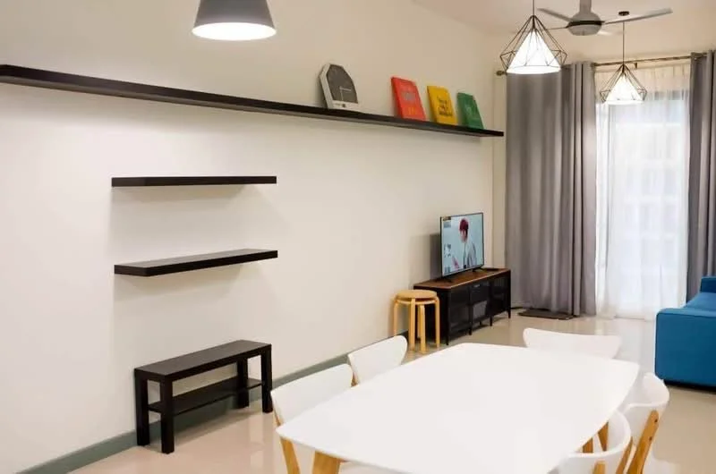 Living features: light grey painted walls, cream tiled flooring, 5-blade ceiling fan with light, pendant lighting, wall-mounted TV, white dining table, 4 white dining chairs, 2 wooden stools, black open shelving unit, blue fabric sofa, floor-to-ceiling curtains, decorative wall art; style: modern.