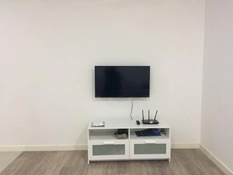 Living features: white painted walls, light wood flooring, wall-mounted TV, white TV console with glass doors, router on console, magazines on console; style: modern.
