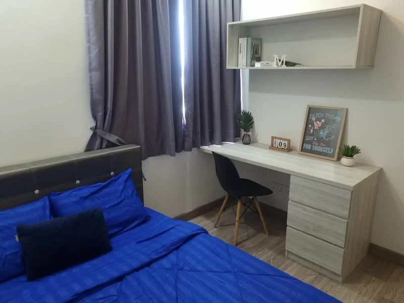 Bedroom features: blue bedding, upholstered headboard, wooden flooring, desk with drawers, black chair, curtains in grey, decorative wall art, houseplant in pot; style: modern.