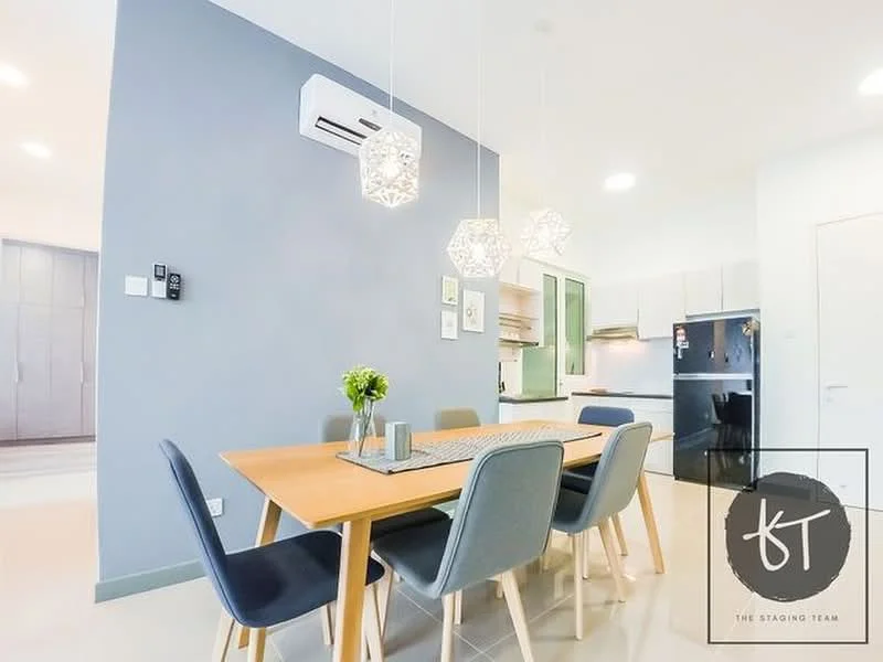 Dining features: 6-seater dining table, wooden dining table, upholstered dining chairs in grey, pendant lighting with geometric design, wall-mounted air conditioning unit, light grey accent wall, white walls, ceramic tile flooring, decorative vase with flowers, framed artwork on wall, open kitchen view in background; style: modern. Kitchen features: stainless-steel fridge, built-in oven, freestanding range oven, white cabinetry, green accent cabinetry, countertop with backsplash, open layout to dining area; style: modern.