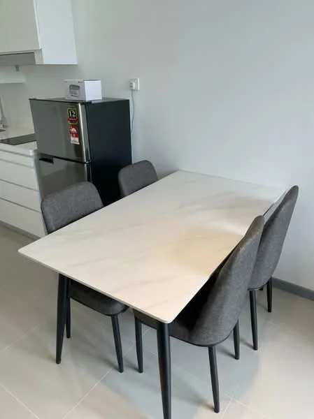 Dining features: marble dining table, 4 dining chairs with grey upholstery, white cabinetry in background, stainless-steel fridge, grey tile flooring, white walls, kitchen area visible in background; style: modern.