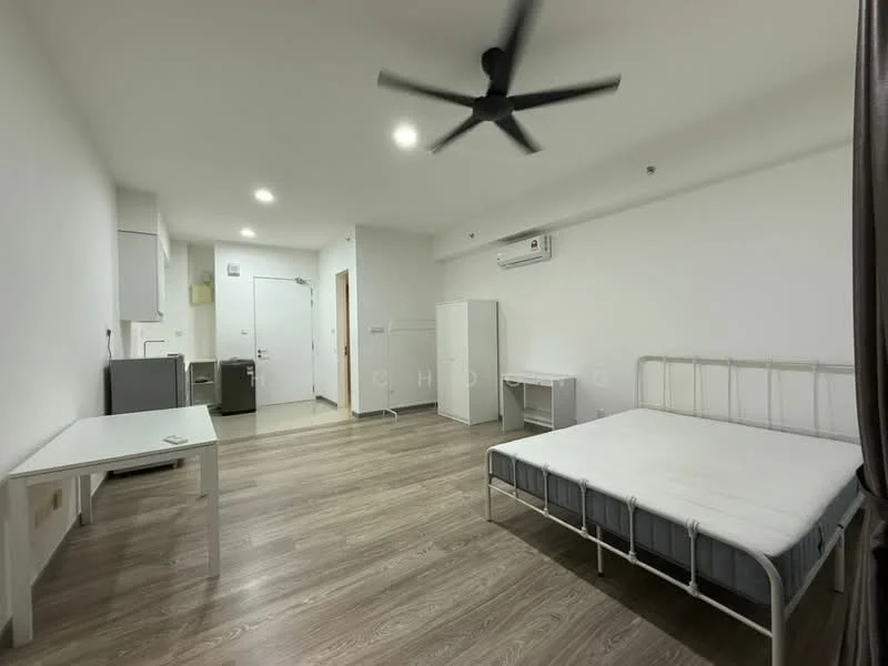 Room features: white painted walls, laminate flooring, 5-blade ceiling fan, wall-mounted split AC, single bed frame without mattress, white desk, white wardrobe, kitchenette with fridge, door to hallway; style: modern.