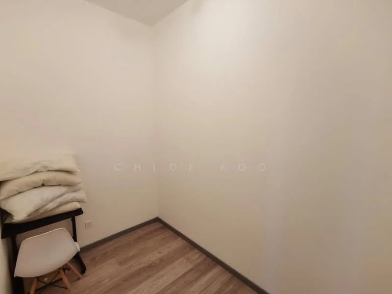 Room features: white painted walls, laminate flooring, stacked bedding, small table, chair.