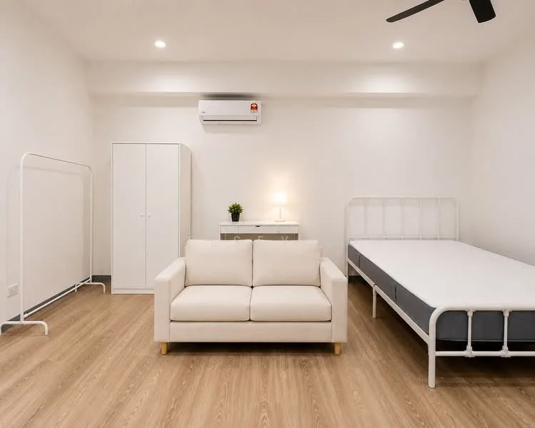 Bedroom features: light wood laminate flooring, white painted walls, 5-blade ceiling fan, wall-mounted split AC, single bed frame without mattress, sofa in cream fabric, white wardrobe with sliding doors, desk with lamp, decorative plant on desk; style: modern.