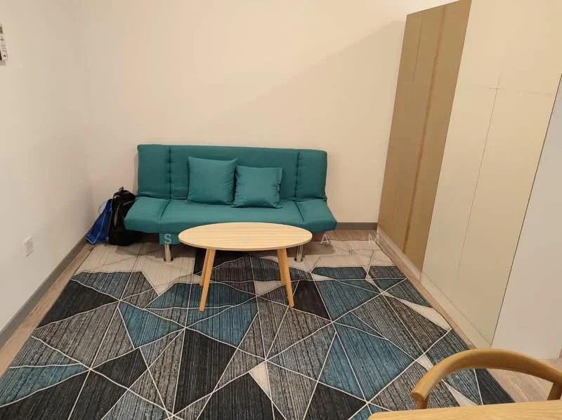 Living features: teal fabric sofa, two teal cushions, round wooden coffee table, area rug with geometric pattern, light-colored tiled flooring, white painted walls, built-in wardrobe, backpack on the floor; style: modern.