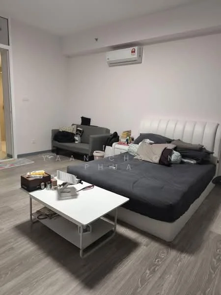 Bedroom features: king-size bed with upholstered headboard, grey bedding, white bedside table, sofa in dark grey, wall-mounted split AC, laminate flooring, light pink painted walls, decorative items on bedside table, clutter on sofa; style: modern.