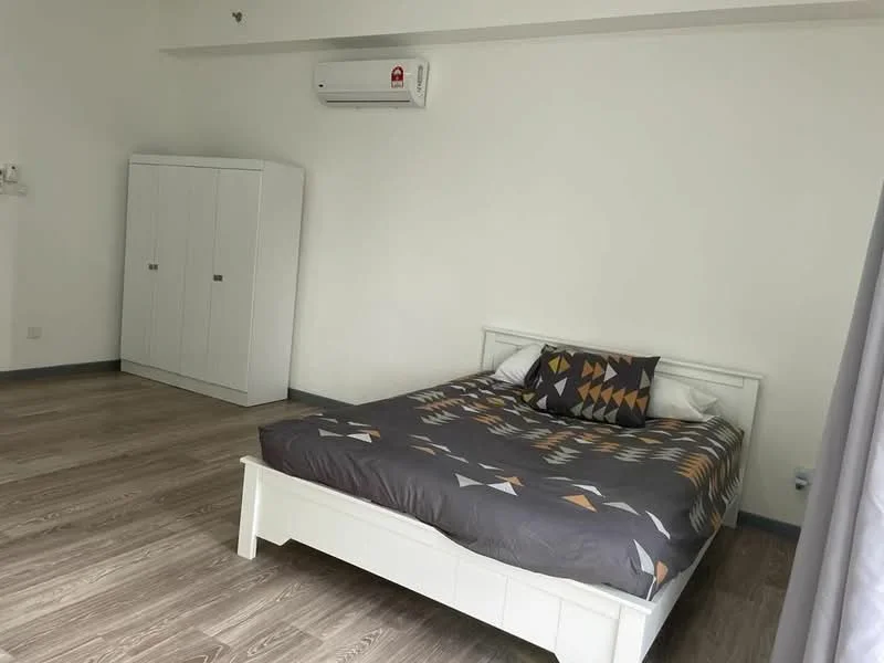 Bedroom features: king-size bed with patterned duvet cover, white wooden bed frame, upholstered headboard, built-in wardrobe with white finish, laminate flooring, 1 wall-mounted split AC, grey curtains, plain white walls; style: modern.