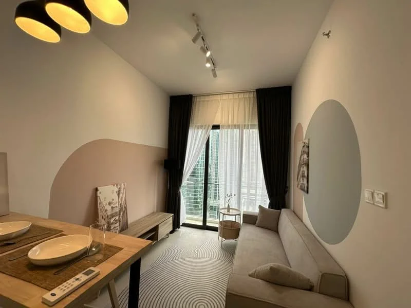 Living features: beige fabric sofa, wooden coffee table, floor-to-ceiling windows, sheer curtains, blackout curtains, recessed downlights, decorative wall with circular patterns, area rug with circular pattern, wall-mounted artwork, TV console, light fixture with multiple bulbs; style: modern; view: city.