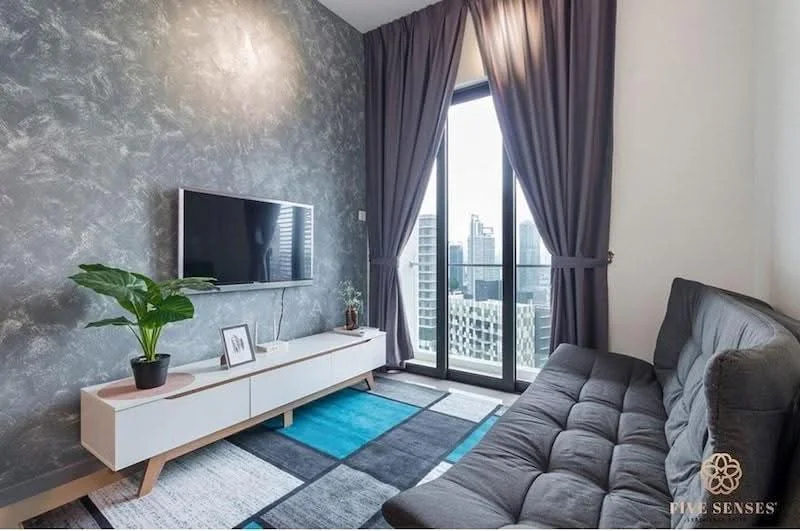 Living features: grey accent wall, floor-to-ceiling windows, sliding glass door, black fabric sofa, TV console with storage, wall-mounted TV, area rug with geometric pattern, indoor plant in ceramic pot, curtains, blue and grey carpet, decorative wall art; style: modern; view: city.