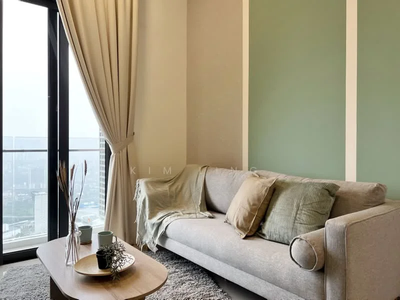 Living features: grey fabric sofa, decorative cushions in green and beige, light wood coffee table, area rug in light grey, floor-to-ceiling windows, sheer curtains, green accent wall, cream painted walls, decorative vase with dried plants; style: modern; view: city.