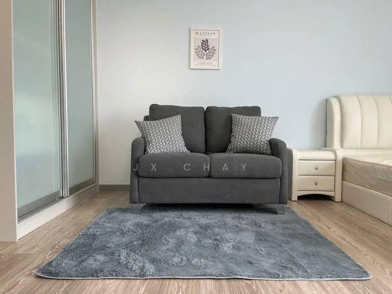 Living features: grey fabric 2-seater sofa, two decorative cushions with geometric pattern, light blue painted walls, wooden flooring, area rug in grey, floor-to-ceiling windows, natural light from windows; style: modern.
