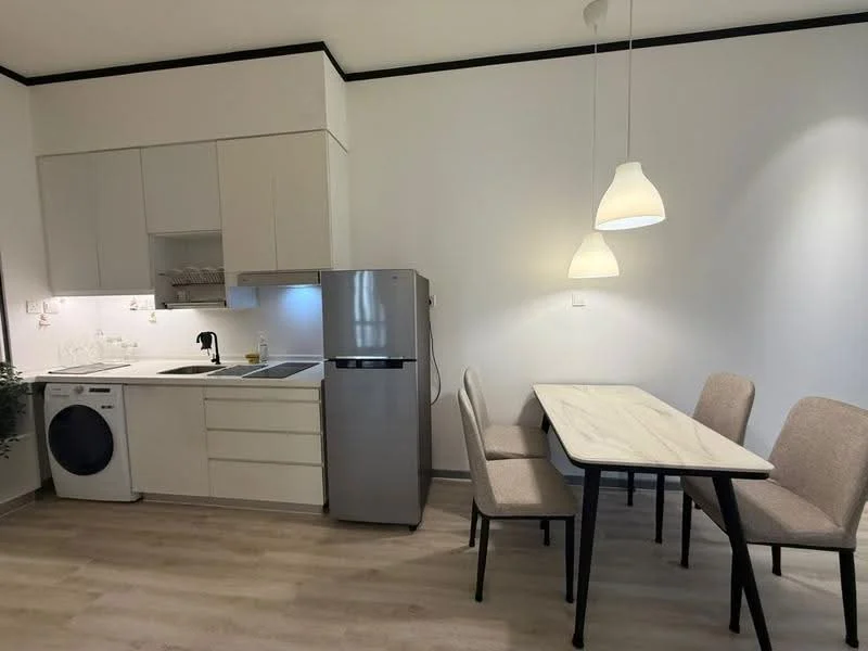 Kitchen features: white cabinetry, stainless-steel fridge, built-in oven, 4-burner gas hob, single-bowl stainless-steel sink, chrome pull-down faucet, white countertop, washing machine, dining table with 4 chairs, pendant lighting, wood-look laminate flooring; style: modern.