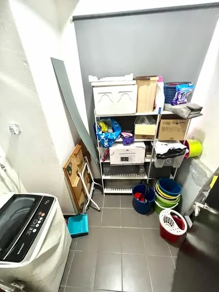 Laundry features: front-load washing machine, metal shelving unit, plastic storage bins in various colors, stacked boxes, cleaning supplies, grey wall, dark tile flooring.
