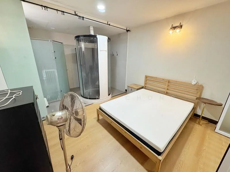 Bedroom features: wooden flooring, white painted walls, single bed frame, mattress, wall-mounted light fixture, standing fan, glass shower enclosure, shower unit, wooden bedside table; style: modern.
