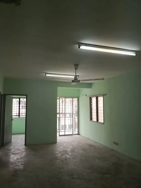 Room features: green painted walls, concrete flooring, ceiling fan, fluorescent ceiling lights, sliding glass door, window with metal grille, open layout, natural light from windows.