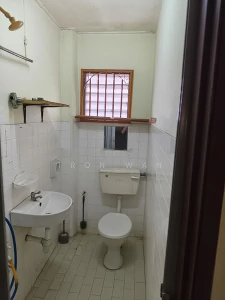 Bathroom features: white tiled walls, white ceramic floor tiles, single-bowl sink, chrome basin mixer faucet, toilet, window with wooden grille, mirror above sink, toilet paper holder, plumbing fixtures visible.