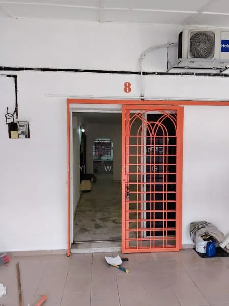 Room features: orange security gate, white painted walls, tile flooring, wall-mounted split AC, visible light source, open doorway, interior space visible beyond the doorway.