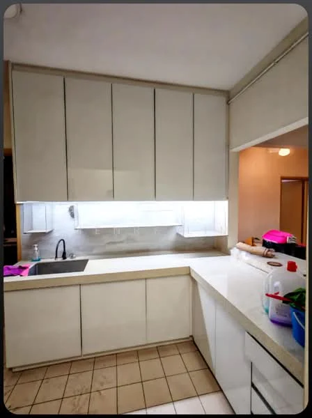 Kitchen features: white cabinetry with flat-panel doors, light-colored countertop, single-bowl stainless-steel sink, chrome pull-down faucet, under-cabinet lighting, tile backsplash, ceramic tile flooring, wall-mounted cabinets, open shelving, kitchen island, appliances visible, kitchen utensils and plants on countertop; style: modern.