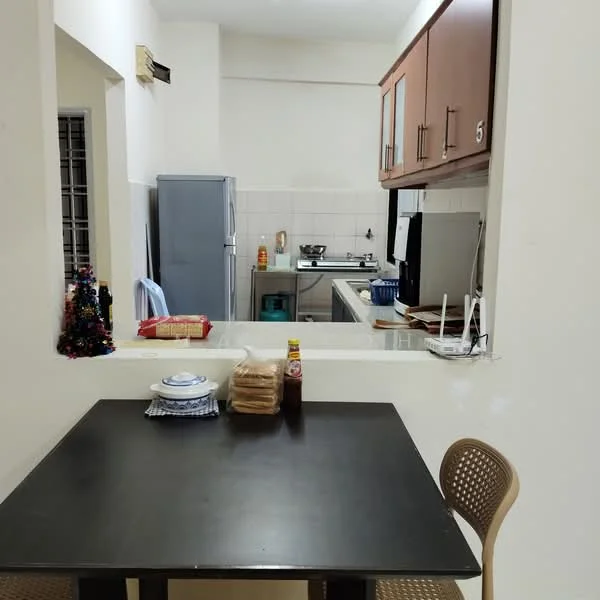 Kitchen features: black dining table, two beige chairs, white tiled walls, light-colored cabinetry, stainless-steel fridge, gas stove with exhaust hood, kitchen sink, countertop with utensils, decorative Christmas tree, bottles and condiments on countertop; style: modern.