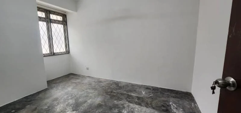 Room features: white painted walls, grey concrete flooring, window with metal grille, single door, keyhole visible.