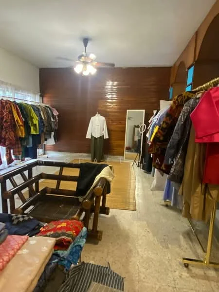 Room features: wood panelled walls, ceiling fan, large mirror, textile display racks, wooden furniture, area rug, natural light from windows, tile flooring; style: traditional.