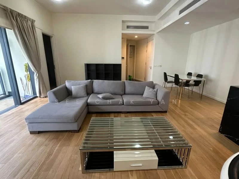 Living features: L-shape sectional sofa in grey, coffee table with glass top and black base, wooden flooring, floor-to-ceiling windows, sheer curtains, decorative throw pillows, black bookshelf, dining area with black dining table and chairs in background; style: modern.