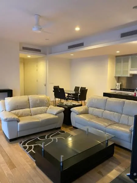 Living features: 2-seater leather sofa in cream, 3-seater leather sofa in cream, glass coffee table, area rug with geometric pattern, ceiling fan, wooden flooring, wall-mounted TV, open-plan layout to dining area; style: modern. Dining features: 4-seater dining table, black dining chairs, open layout to living area; style: modern.