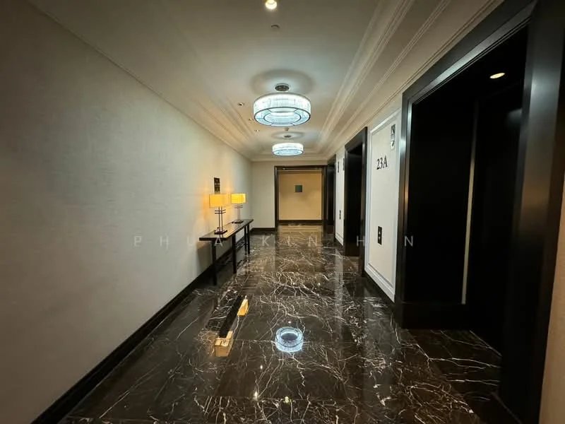 Hallway features: marble flooring, recessed ceiling lights, chandeliers, elevator access, wall-mounted light fixtures, decorative wall paneling, neutral wall color, numbered room doors; style: modern.
