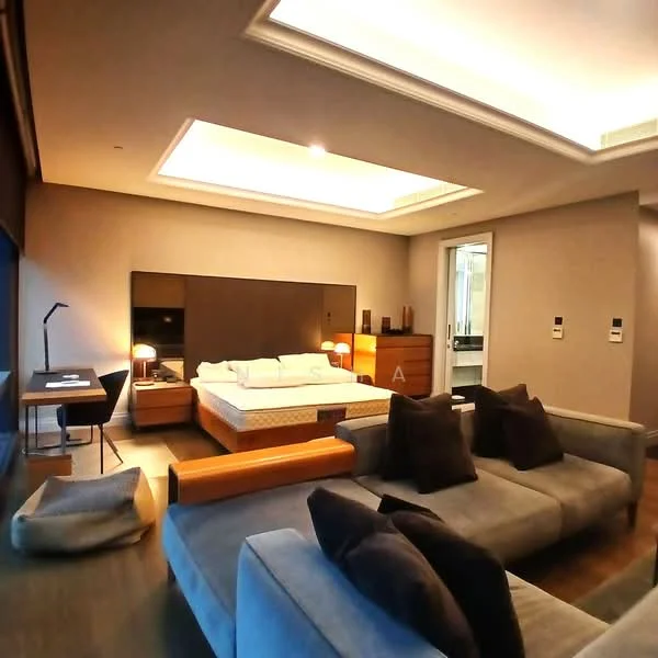 Bedroom features: king-size bed, upholstered headboard, 2 bedside lamps, wooden dresser, wall-mounted mirror, sofa with cushions, floor lamp, recessed ceiling lights, dark wood flooring, grey painted walls, ceiling with tray design, large window with blackout curtains; style: modern.