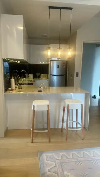 Kitchen features: white cabinetry, black countertop, stainless-steel fridge, stainless-steel sink, chrome pull-down faucet, 3 pendant lights, bar stools with wooden legs, open layout, wooden flooring, wall-mounted cabinets, built-in oven, microwave; style: modern.