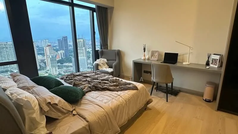 Bedroom features: king-size bed with beige bedding, green decorative pillows, wooden flooring, floor-to-ceiling windows, city skyline view, armchair in grey fabric, desk with laptop, desk lamp, decorative vase, framed photo, wall-mounted mirror; style: modern; view: city.