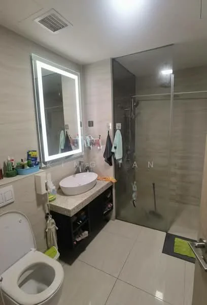 Bathroom features: white ceramic toilet, single-sink vanity with countertop, round basin sink, chrome basin mixer faucet, full-height glass shower enclosure, rain shower head, wall-mounted mirror with LED backlight, light-colored wall tiles, grey floor tiles, towel rack, various toiletries on vanity; style: modern.