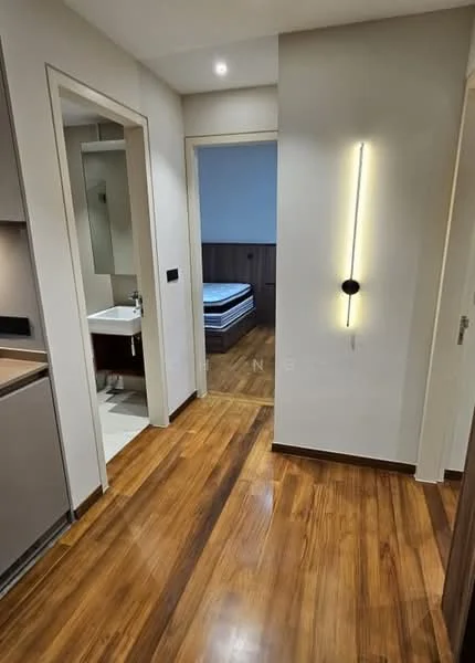 Room features: wooden flooring, neutral painted walls, recessed lighting, wall-mounted light fixture, doorway leading to another room, doorway leading to bathroom, visible bed in adjacent room; style: modern.