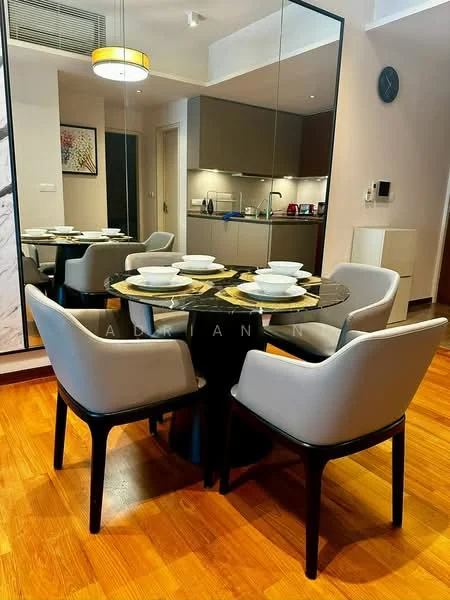 Dining features: round dining table with black marble top, 4 upholstered dining chairs in light grey, wooden flooring, pendant light fixture, mirror wall, kitchen area visible in the background, decorative artwork on wall, table setting with white plates; style: modern.