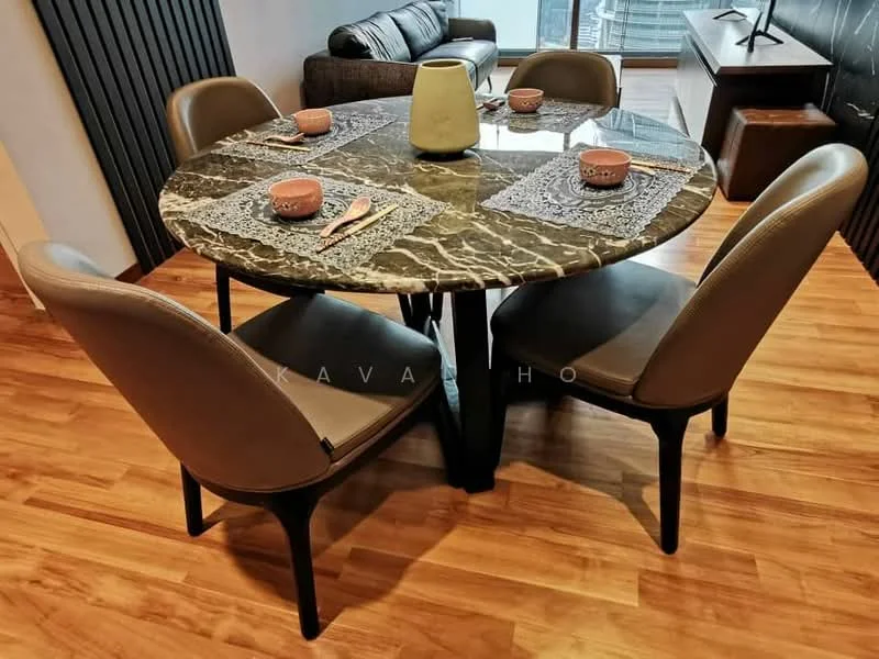 Dining features: round marble dining table, 4 upholstered dining chairs in beige, wooden flooring, decorative placemats, ceramic vase on table, cutlery on table, wall-mounted TV in background, sofa in background; style: modern.
