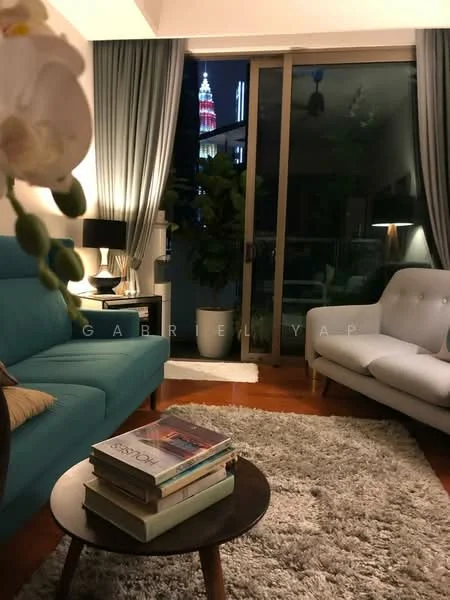 Living features: teal fabric sofa, light grey fabric sofa, round coffee table, stack of books on coffee table, area rug with plush texture, floor-to-ceiling windows, curtains in grey, indoor plant, table lamp, decorative vase with orchid; style: modern; view: city.