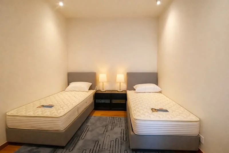 Bedroom features: two single beds with grey upholstered headboards, mattresses on beds, two bedside tables, two table lamps, light-coloured walls, wooden flooring, recessed ceiling lights, area rug with geometric pattern; style: modern.