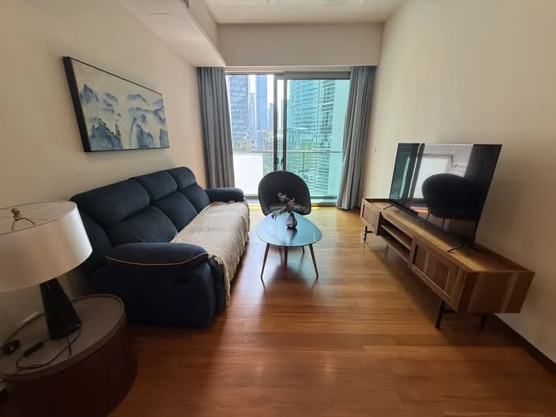 Living features: 3-seater fabric sofa in navy blue, wooden coffee table, TV console with storage, wall-mounted TV, floor-to-ceiling windows, curtains, laminate flooring, decorative lamp, decorative vase on table, city view from window; style: modern; view: city.