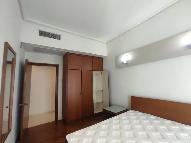 Bedroom features: wooden flooring, white painted walls, ceiling lights, built-in wardrobe with sliding doors, mirror on wall, queen-size bed frame, mattress, window with natural light, doorway leading to hallway; style: modern.