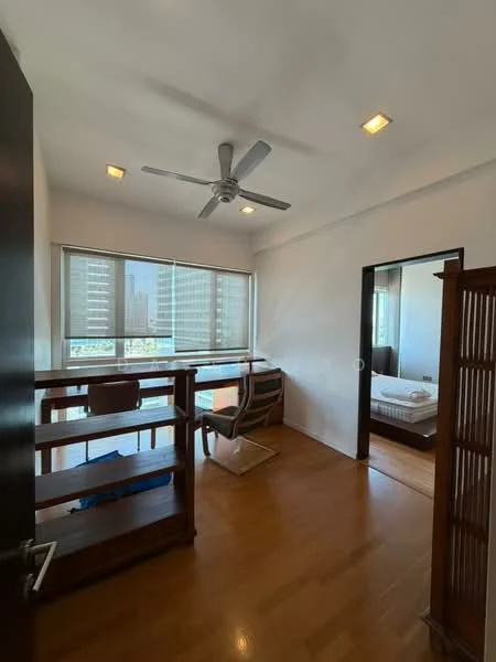 Room features: wooden flooring, white painted walls, 5-blade ceiling fan with light, floor-to-ceiling windows, roller blinds, study desk, wooden shelving unit, armchair, bed visible in adjacent room; style: modern; view: city.