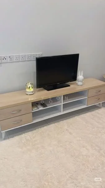 Living features: light wood TV console with drawers, black flat-screen TV, decorative items on console, cream area rug, grey wall, multiple power outlets on wall; style: modern.