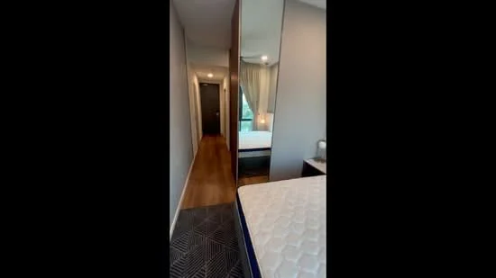 Room features: wooden flooring, grey accent wall, mirrored wardrobe, bed with mattress, curtains, recessed lighting, doorway leading to another room, visible bed frame; style: modern.