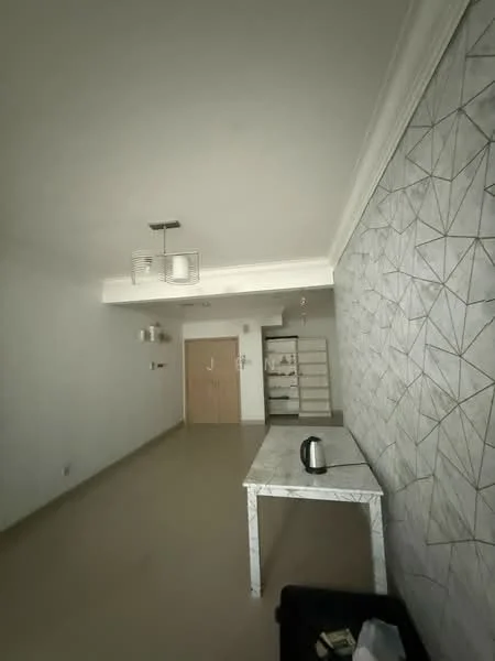 Living features: white painted walls, geometric patterned accent wall, cream tiled flooring, ceiling with recessed lighting, hanging light fixture, table with marble top, kettle on table, open space layout; style: modern.