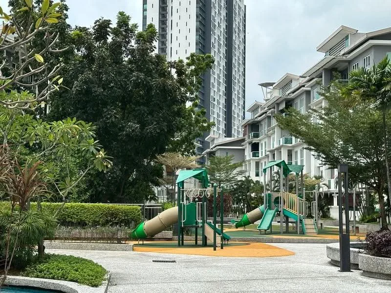 Exterior type: mid-rise condominium; features: children's playground with slides, green play structures, manicured landscaping, surrounding trees, paved walkway, adjacent high-rise building, outdoor seating area; style: modern.