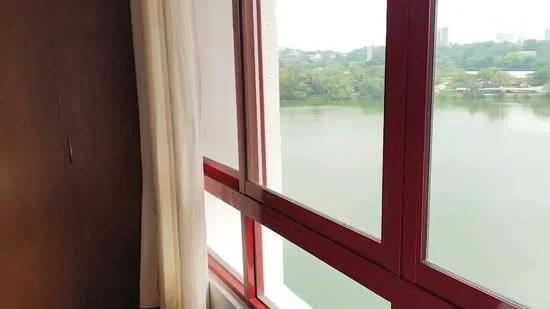 Room features: red framed windows, sheer curtains, view of water, view of greenery, interior wall with brown finish; view: water.